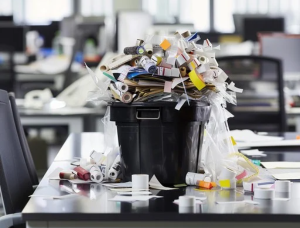 Overflowing office bin with rubbish